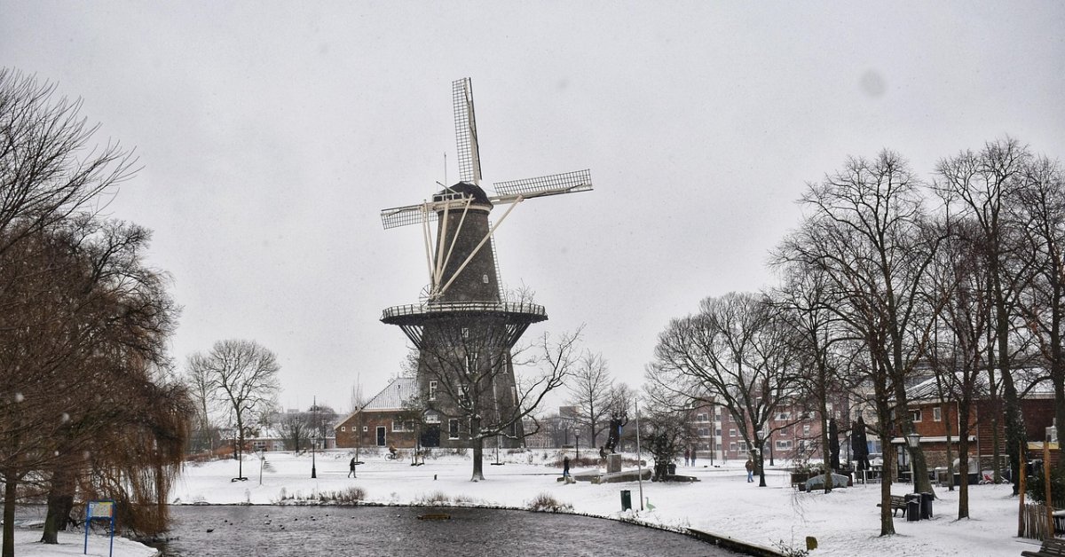 Molen De Valk staat aan een besneeuwde gracht in Leiden.